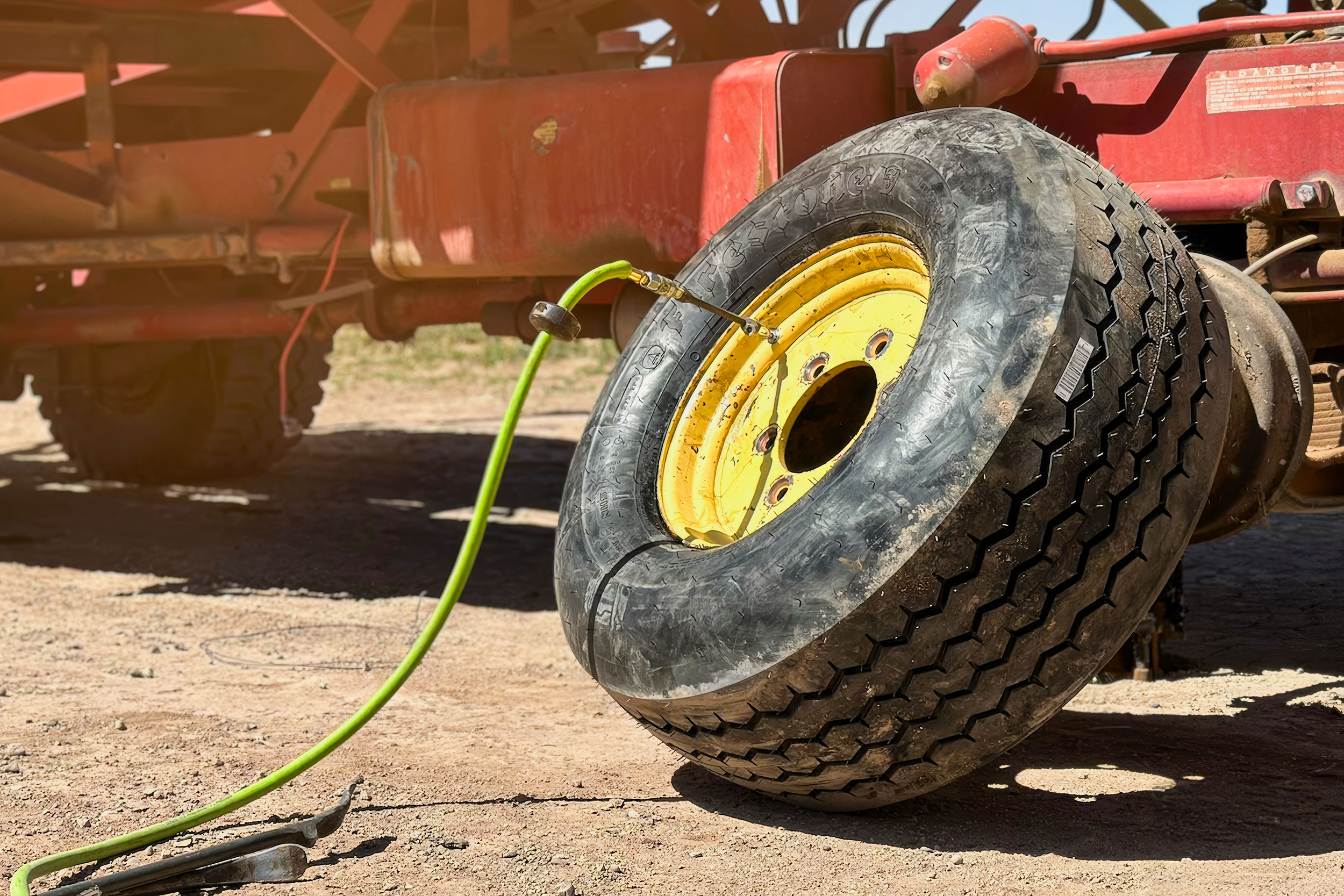 Mechanic changing a tire on a balewagon on a farm near Deming, NM
